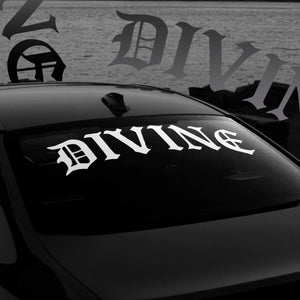 Car window with 'DIVINE' decal and blurred background
